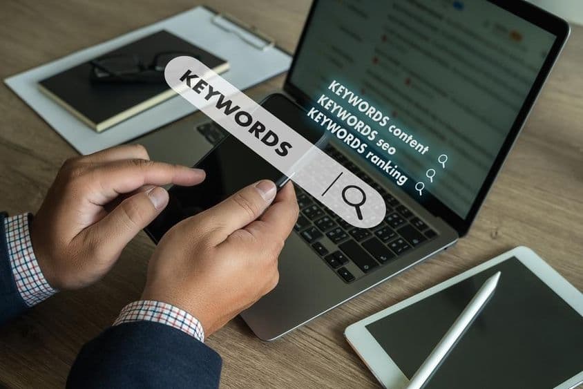 Üzletember keressen a webhelyen a tartalom kulcsszavaira laptopon.
