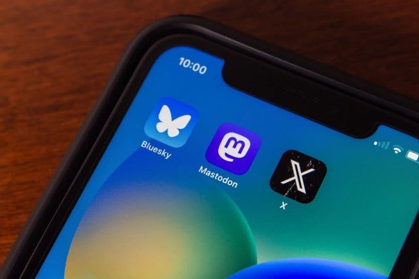 Bluesky és X alkalmazás ikonok egy iPhone képernyőjén.
