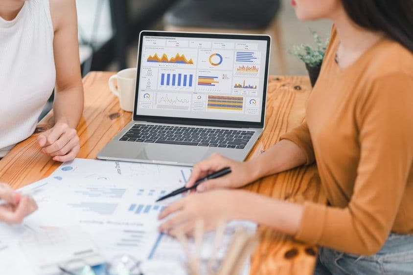 Két szakember üzleti adatokat elemez a képernyön.