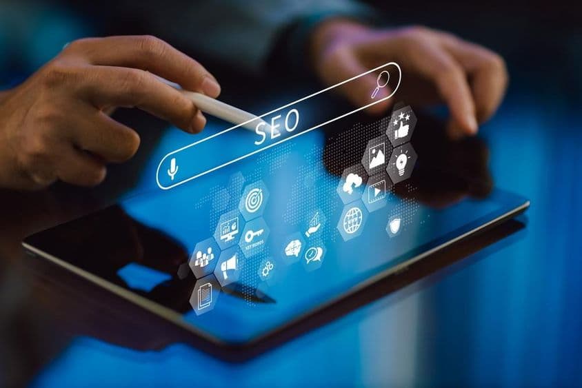 Laptoppal dolgozó személy keresőoptimalizálás közben: SEO közösségi média tartalommal.