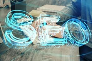 Dupla expozíció SEO ikonnal, háttérben számítógépen dolgozó férfival.