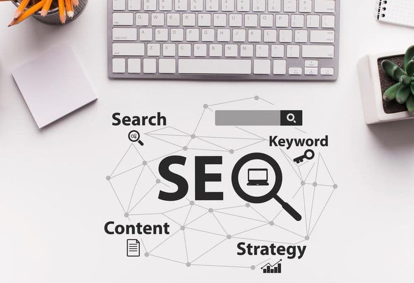 SEO-optimalizálási terv szavakkal fehér irodai asztal háttere és számítógép-billentyűzet felett.