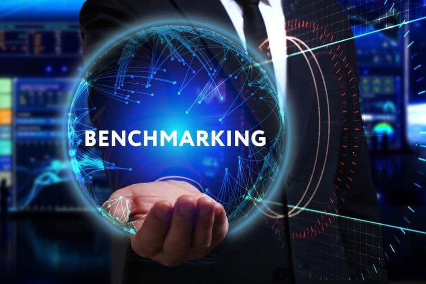 Fiatal üzletember dolgozik a jövő területén, és a feliratot látja: benchmarking.
