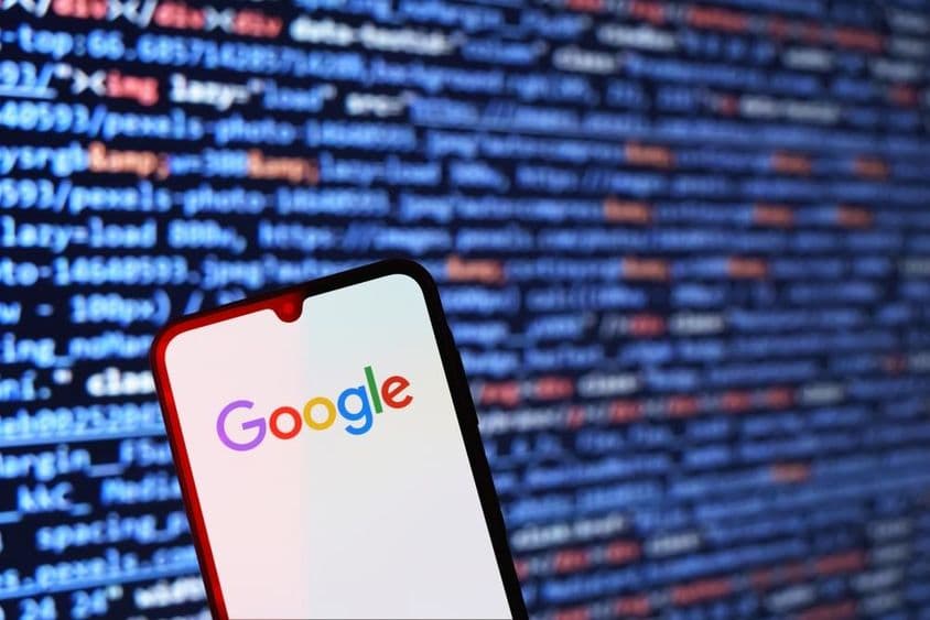 Okostelefon egy felületen, amin a Google logó látható.