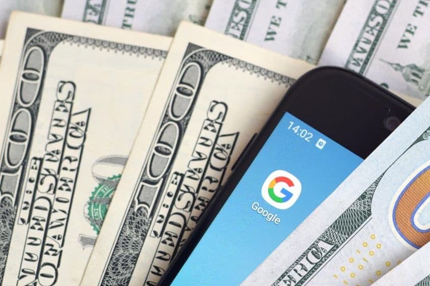 Okostelefon képernyő Google alkalmazással és sok százdolláros bankjeggyel.