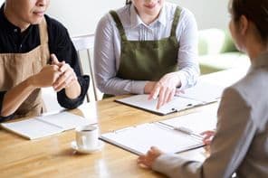 Étteremvezető hallgatja az üzletasszony prezentációját.