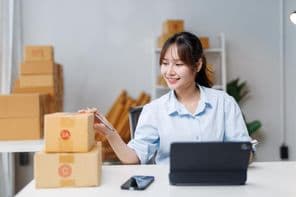 Mosolygó fiatal nő pakolja az árút.